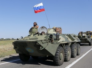 Russian military personnel ride atop APCs outside Kamensk-Shakhtinsky