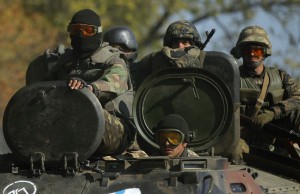 Ukrainian servicemen ride on an armoured vehicle near Debaltseve